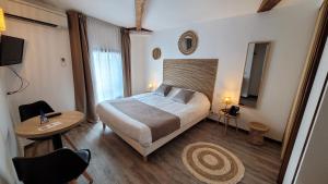 a hotel room with a bed and a table and a table sidx sidx at Le Relais du Valois, Cognac Centre in Cognac