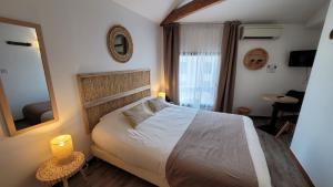 a bedroom with a large bed and a mirror at Le Relais du Valois, Cognac Centre in Cognac