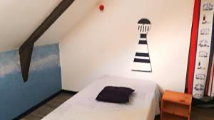 - une chambre avec un lit et un phare sur le mur dans l'établissement Maison de 2 chambres avec jardin amenage et wifi a Questembert, à Questembert
