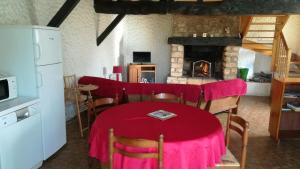 une salle à manger avec une table et une cheminée dans l'établissement Maison de 2 chambres avec jardin amenage et wifi a Questembert, à Questembert