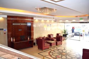 a lobby with a couch and chairs and a chandelier at Palm Beach Hotel in Dubai