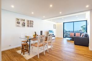 uma sala de jantar e sala de estar com mesa e cadeiras em Magnolia Apartment by Atlantic Holiday no Funchal