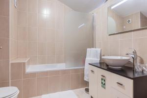 a bathroom with a sink and a toilet and a tub at Savana Apartment By Atlantic Holiday in Caniço +23 photos