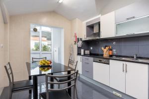 a kitchen with a table and some chairs in a room at Savana Apartment By Atlantic Holiday in Caniço