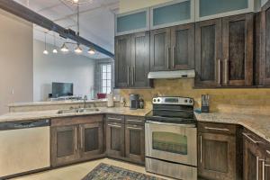 La cuisine est équipée de placards en bois et d'un four avec plaques de cuisson. dans l'établissement Bright Savannah Loft in Historic District!, à Savannah