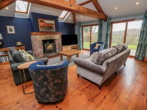 uma sala de estar com sofás e uma lareira em Ridley Lodge em Morpeth