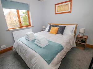 um quarto com uma cama com toalhas em Ridley Lodge em Morpeth