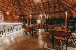 uma sala de jantar com mesas e cadeiras num edifício em El Pez Surf Hotel em Popoyo