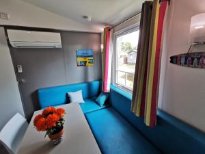 a train room with a table and a vase of flowers at Mobil home 6 Personnes au Atlantic Club Montalivet in Vendays-Montalivet