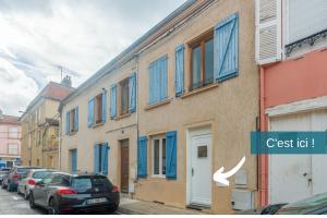 a building with blue windows and cars parked on a street at CHOUETTISSIME Topséjour-Roanne 1 chambre All Inclusive in Roanne +3 photos