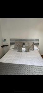 トレホン・エル・ルビオにあるSueños de Monfragueのベッド(白いベッドカバー、枕付)