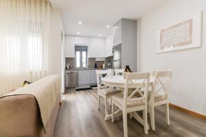eine Küche und ein Esszimmer mit einem Tisch und Stühlen in der Unterkunft Tiana Apartment - City Centre with Terrace in Viana do Castelo