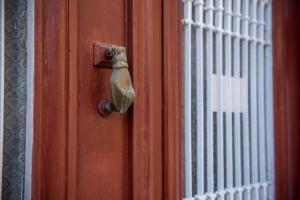 a wooden door with a metal door knocker on it at 1920s Rooms in Kalamata