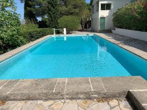 a swimming pool with blue water in a yard at VIlla Saint Clair avec piscine in Sète