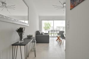 una sala de estar con un sofá y una mesa en T2 NEUF A4 RDJ-PISCINE–ACCÈS DIRECT PLAGES ET CENTRE VILLAGE–, en Saint-Cyr-sur-Mer
