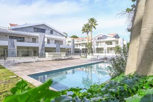una imagen de una piscina frente a un edificio en T2 NEUF A4 RDJ-PISCINE–ACCÈS DIRECT PLAGES ET CENTRE VILLAGE–, en Saint-Cyr-sur-Mer