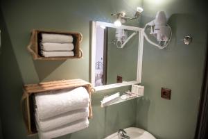 a bathroom with a toilet and a mirror and towels at 1920s Rooms in Kalamata