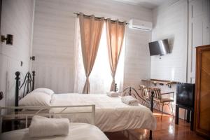 a bedroom with two beds and a window at 1920s Rooms in Kalamata