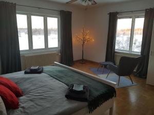 una camera da letto con un letto, una sedia e finestre di The Friendly Moose a Övertorneå