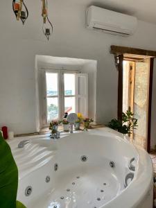 a large white bath tub in a room with windows at El Jardín de Lucas in Arcos de la Frontera +56 photos