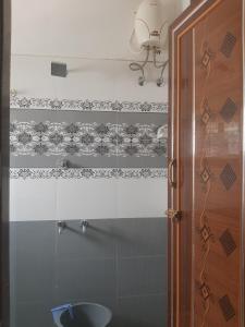 a bathroom with a shower with a glass door at Padmavathi Home Stay in Chidambaram