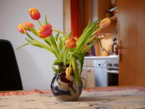 un jarrón con flores en él sentado en una mesa en Haus Jurisch, en Urberg