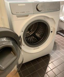 Há uma máquina de lavar roupa ao lado de um WC. em Budget Small Room City Centre em Oslo