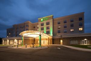a hospital building with a lit up sign in front of it at Holiday Inn & Suites Detroit - Troy, an IHG Hotel in Troy
