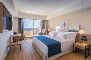 ein Hotelzimmer mit einem großen Bett und einem Balkon in der Unterkunft Barceló Lanzarote Royal Level in Costa Teguise