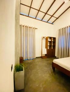 um quarto com uma cama e um quarto com cortinas em Nilupul Villa em Ambalangoda