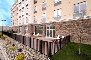 a building with a fence and chairs in a yard at Holiday Inn & Suites Detroit - Troy, an IHG Hotel in Troy