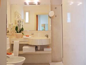 a bathroom with a sink and a toilet and a mirror at Hotel HamilTown in Cattolica