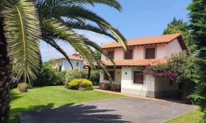 a house with a palm tree and a driveway at Vivienda Vacacional Villa Costa Cué in Cue