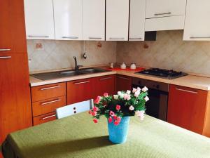 a kitchen with a table with a blue vase with flowers at LES PETITES MAISONS maison orange in Procida
