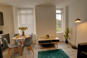 a kitchen and living room with a table and chairs at Bright and stylish one bedroom apartment in Dundee