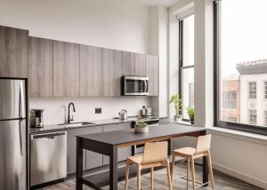 a kitchen with a table and chairs and a refrigerator at ROOST Cleveland in Cleveland