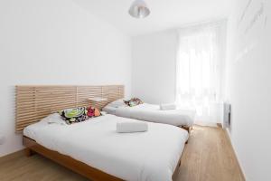 Duas camas num quarto com paredes brancas e uma janela em Large 2 Bdr at Nice Port em Nice