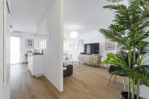 a living room with white walls and a large plant at Large 2 Bdr at Nice Port in Nice