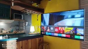 einen großen Flachbild-TV an der Wand in einer Küche in der Unterkunft Presidente Deluxe in Sierra Nevada