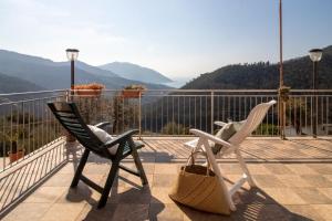 - deux chaises sur un balcon avec vue sur les montagnes dans l'établissement Villa Le Macine, à Molino Nuovo