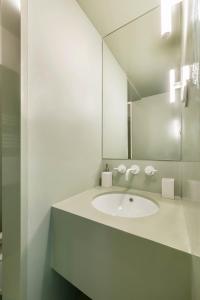 a white bathroom with a sink and a mirror at Jardim Suites by Olala Homes in Cascais