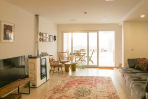 a living room with a couch and a table with chairs at Modernes Haus mit spektakulärem Meerblick und Pool in Vale Furado