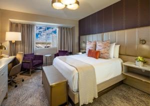a hotel room with a large bed and a desk at SAHARA Las Vegas in Las Vegas