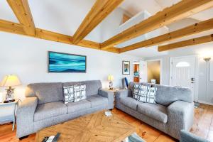 una sala de estar con 2 sofás y techos de madera. en Cozy Charming Cottage, en Brewster
