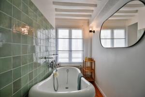 une salle de bain avec une baignoire et un miroir dans l'établissement Les Oiseaux du Corsaire 3 House & Terrace 6 P - Center Honfleur, à Honfleur 24 autres photos