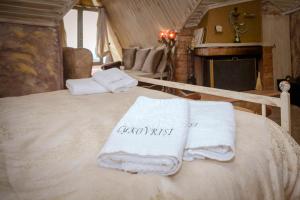 1 dormitorio con 1 cama con toallas en Lykovrisi Guest House en Arachova