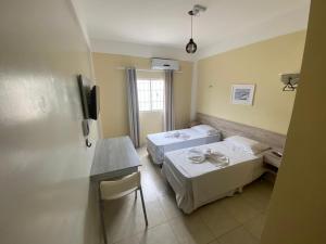 ein Krankenhauszimmer mit 2 Betten und einem Tisch in der Unterkunft GRAN PARADA HOTEL in Castanhal