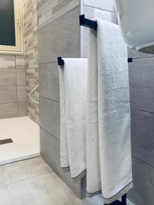 bagno con asciugamani bianchi appesi a uno portasciugamani di Regina a Tropea