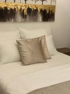 un letto con cuscini bianchi e un dipinto sul muro di Regina a Tropea