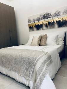 una camera da letto con un grande letto con lenzuola bianche di Regina a Tropea